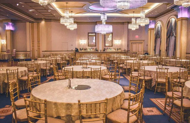 An event room set with round tables beneath chandeliers