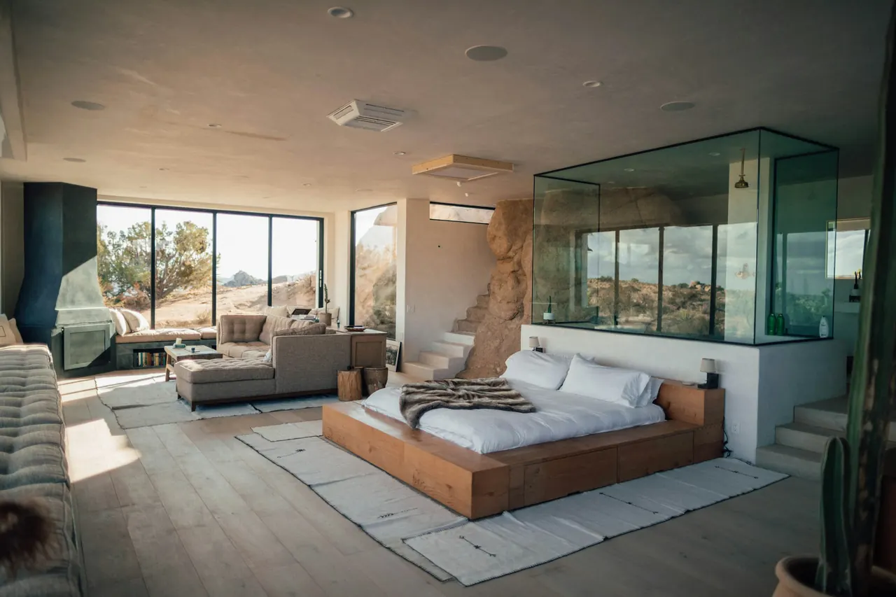 A bright hotel suite with a seating area beside tall windows
